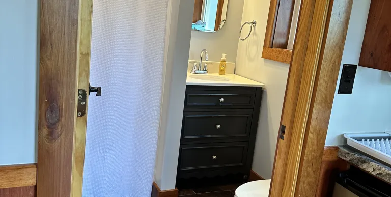 Couch with side tables and sconces surrounding adirondack art