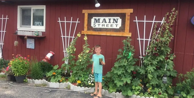 An excited child stands with mother under the Main Street Restaurant sign.