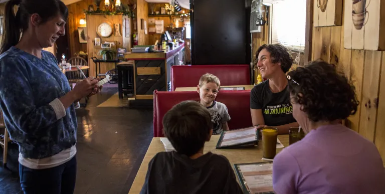A family sits in a booth with menus.