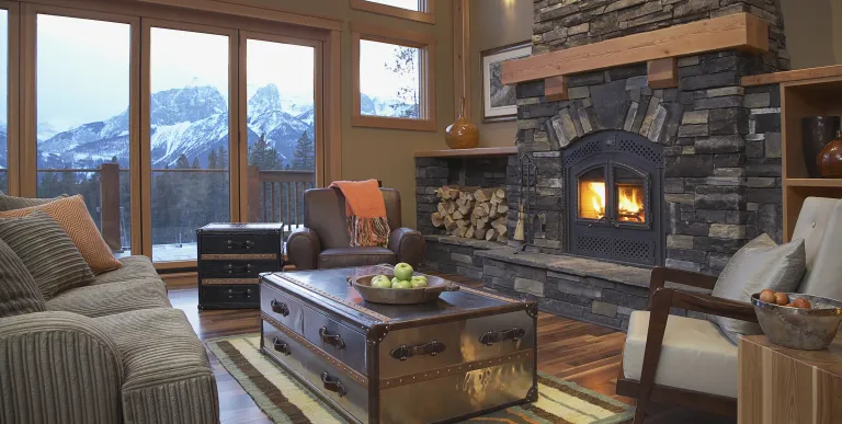 A grand living room with stone hearth and mountain views