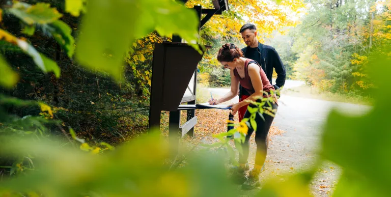 A couple signing into the Goodman Mountain trailhead register