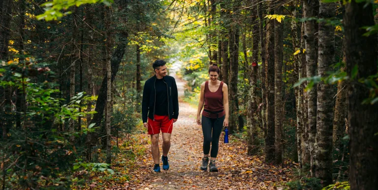 A couple walking along a flat trail during fall
