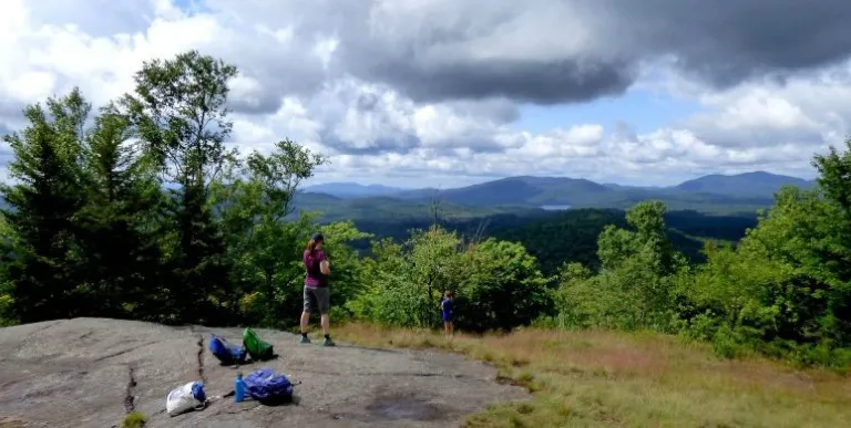 A hiker a top a partially open mountain