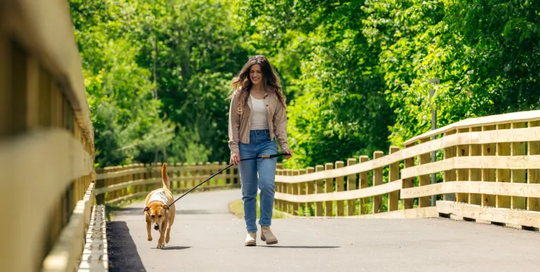 A woman walking her dog on the Rail Trail