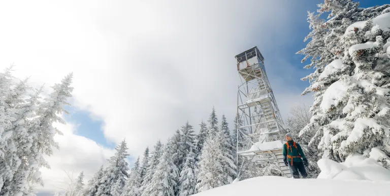 A snowshoer near the firetower on Owls Head Mountain in the winter