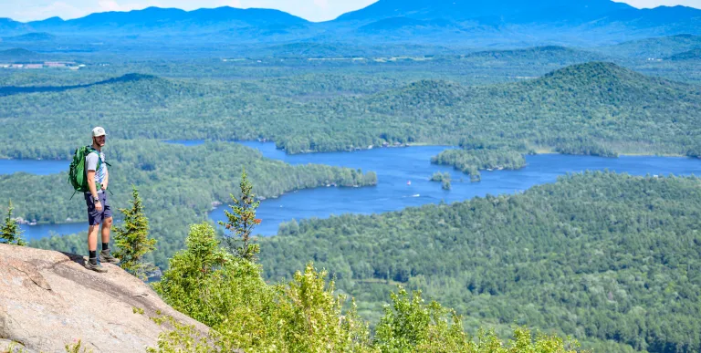 A man standing on the summit of St Regis Mountain