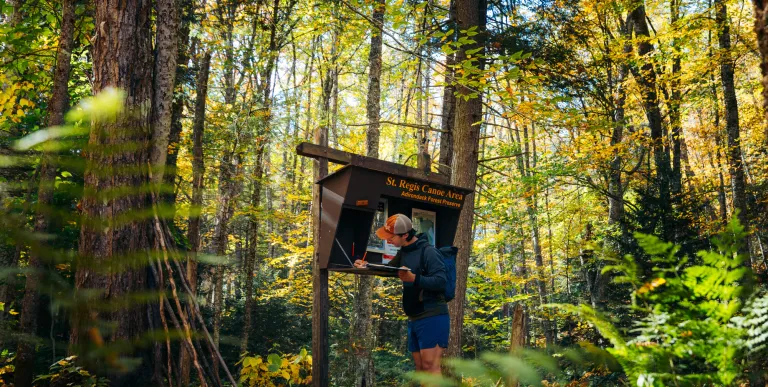 A hiker signing into the register for a mountain