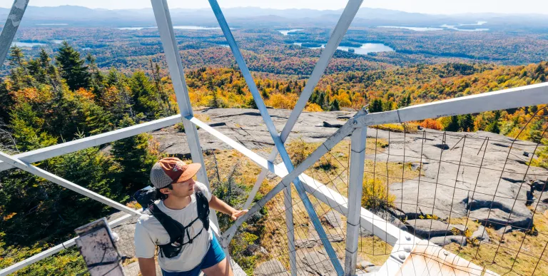 A hiker going up a fire tower in the fall