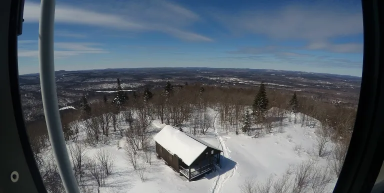 Two people look towards a firetower