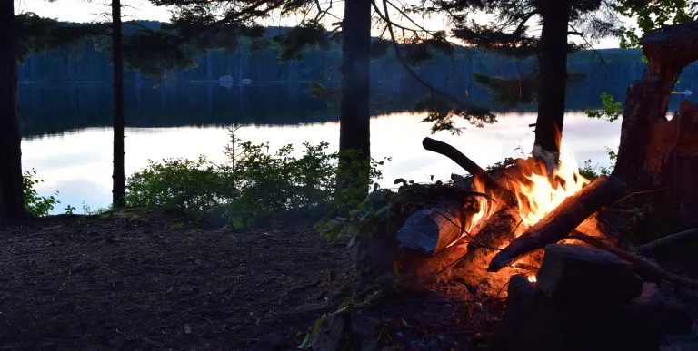 A campfire at the edge of the water