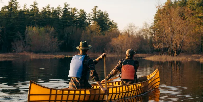 A pack boat with two people on a river