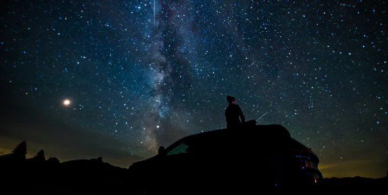 A person on their car stargazing