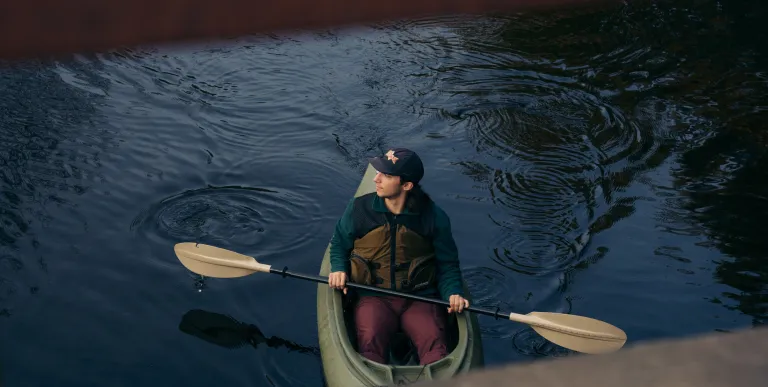 A kayaker seen through a bridge