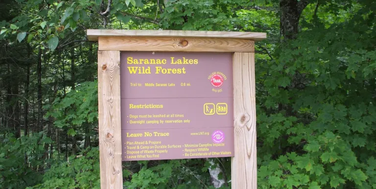 A wooden sign for the Saranac Lakes Wild Forest