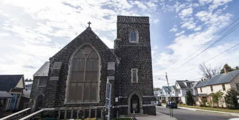 Exterior of the tall grey stone church