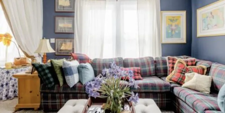 The formal sitting area with large window and plaid sectional couch