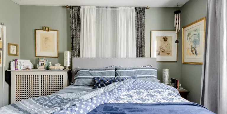 A bright and light three season room with linen curtains and cane furniture.