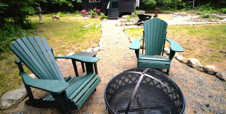 Outdoor fireplace and green adirondack chairs at Rockledge Cabins & Retreats 
