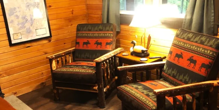 The living space with two rustic armchairs at Rockledge Cabins & Retreats 