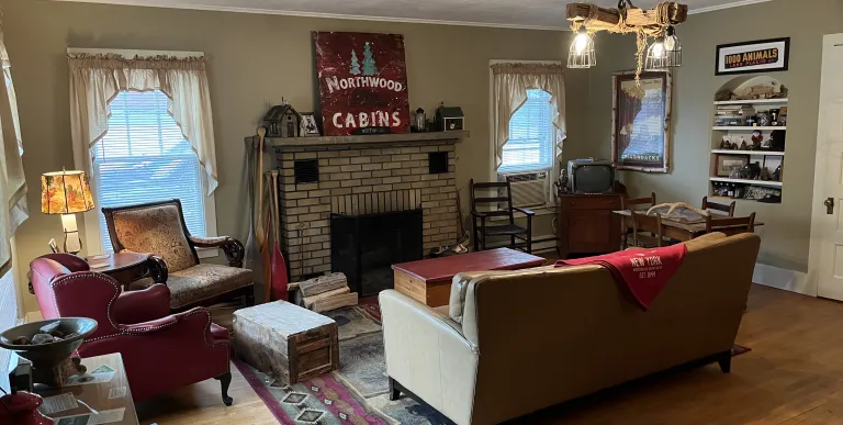 A roaring fire in a brick fire place and Northwoods Cabin sign on the mantle.
