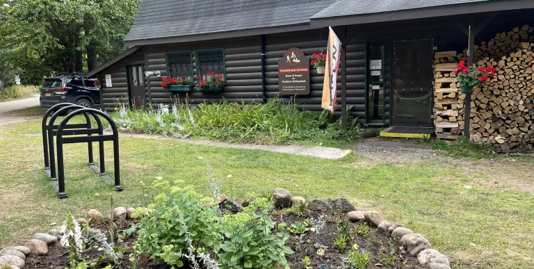 Exterior of the Floodwood Outpost with small garden and bike rack.
