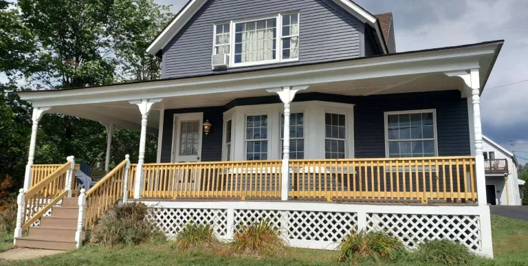 A blue house with white trim at the Sara Placid Inn & Suites.
