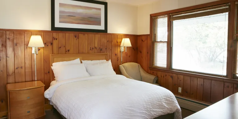 Plush white linens on a king bed at The Ashley.